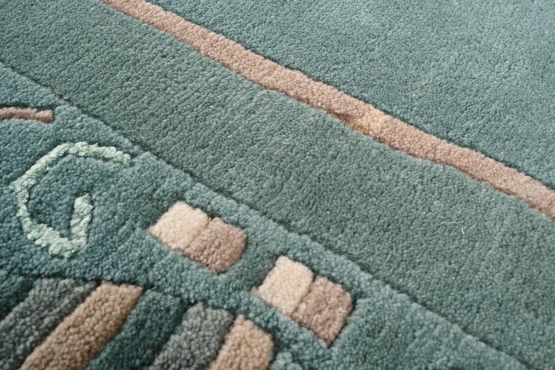 Handgeknüpfter Tibeter Teppich in grün mit Retro Bordüre – Neuwertig