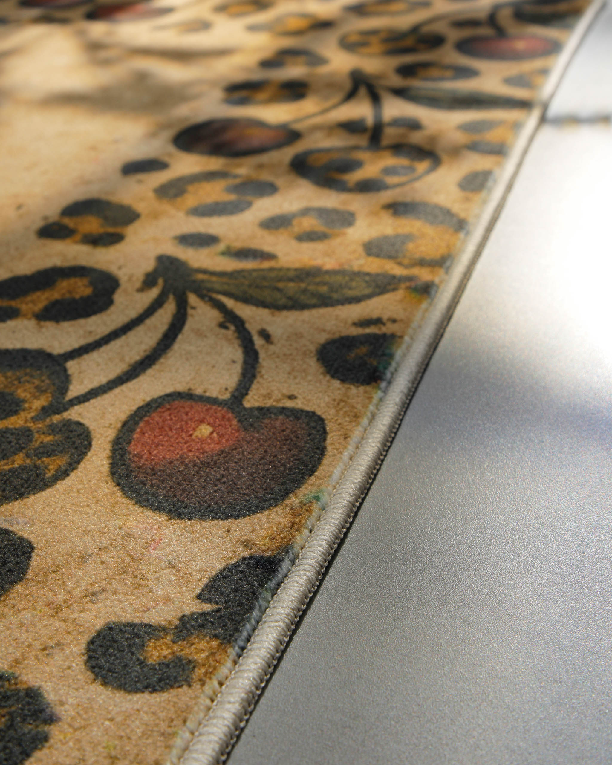 Nahaufnahme der eingefassten Kante des Badteppichs Catwalk mit dekorativem Animal-Print.