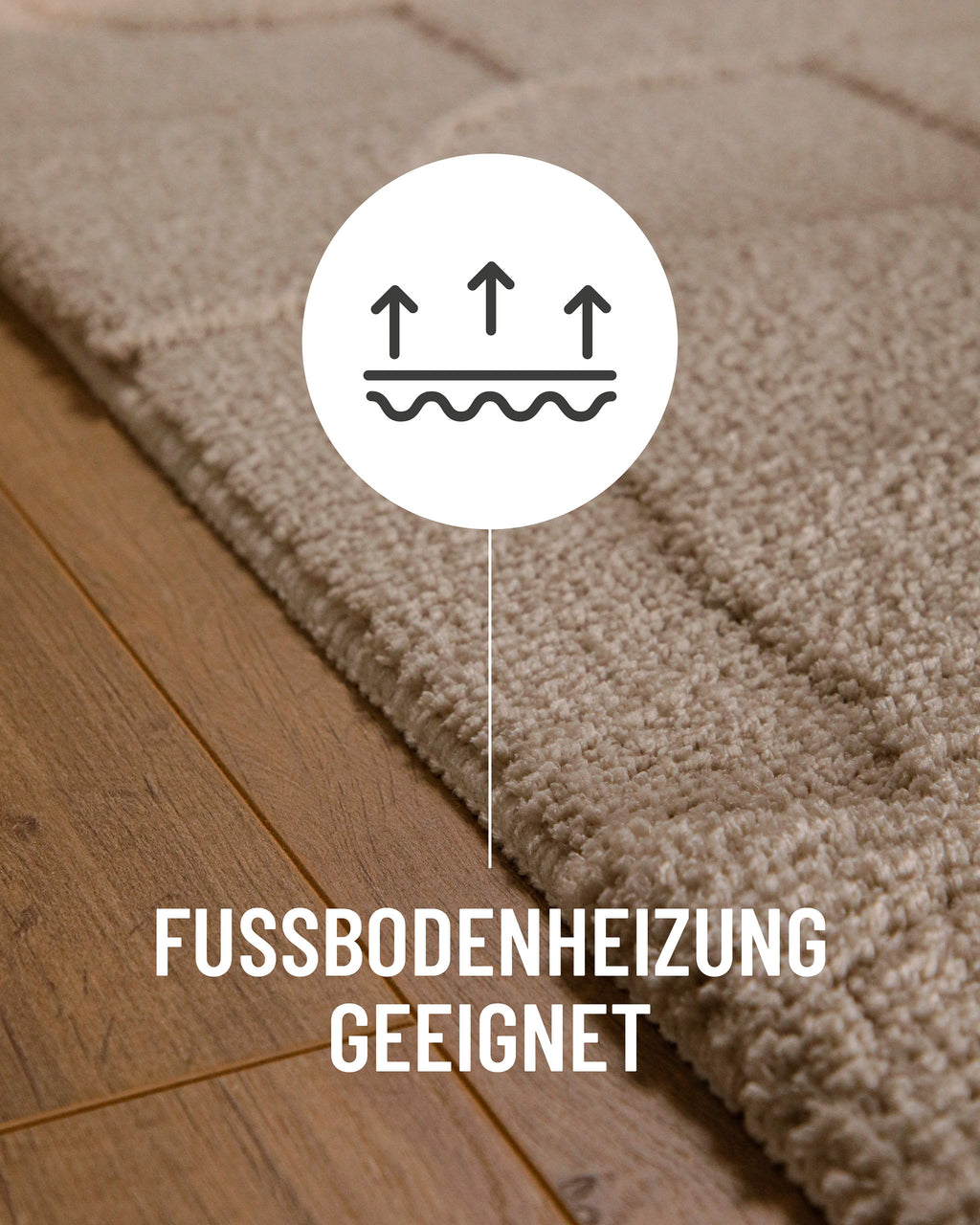 Badteppich von BathKing by WECONhome Davie Sand Beige Detail auf Holzfußboden mit Symbol für Fußbodenheizung, Nahaufnahme von Flor und Teppichkante