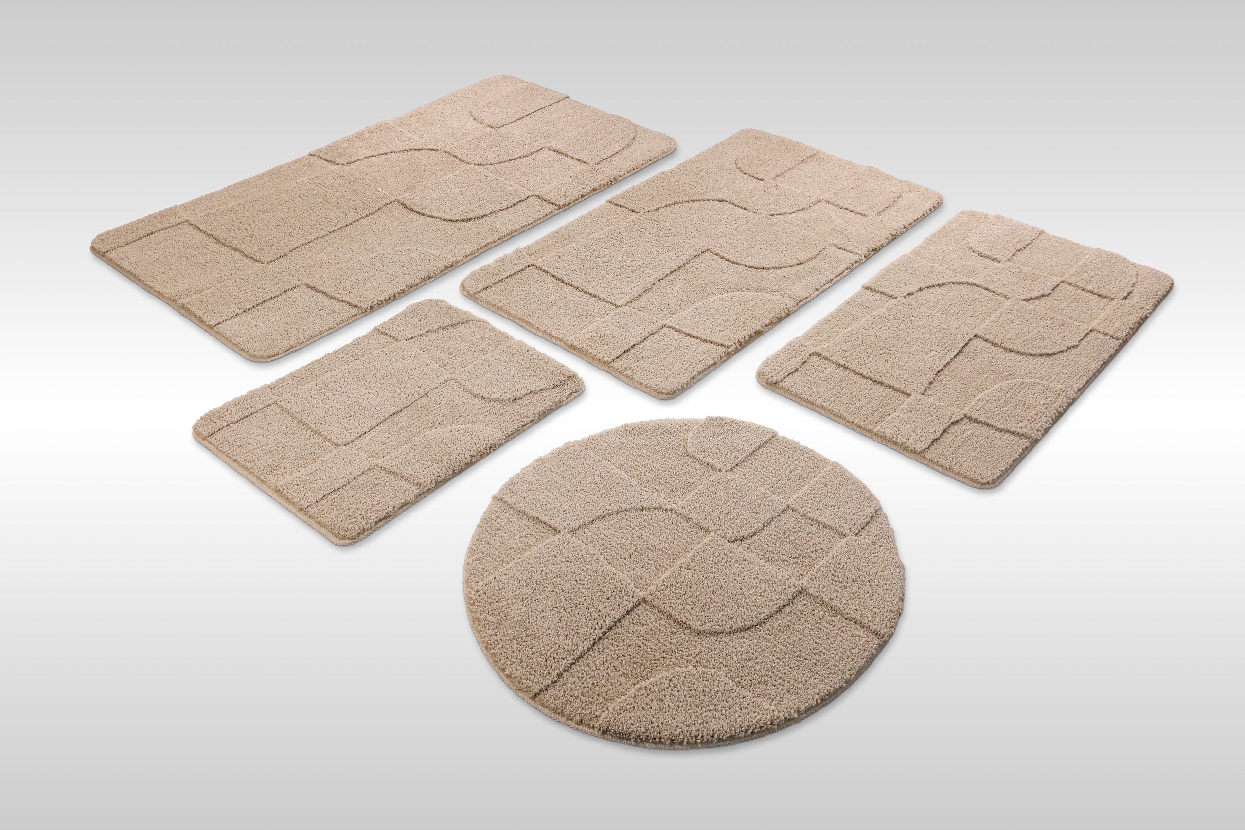 Badteppich von BathKing by WECONhome Davie Sand Beige Set aus rechteckigen und runden Badmatten, mehrere Größen auf hellem Hintergrund angeordnet