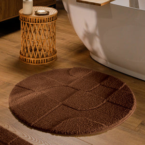 {"class" => "product-thumbnails__image", "alt" => "Runder Badteppich von BathKing by WECONhome Davie Braun im Badezimmer vor Badewanne auf Holzboden, strukturiertes Linienrelief im Flor sichtbar"}