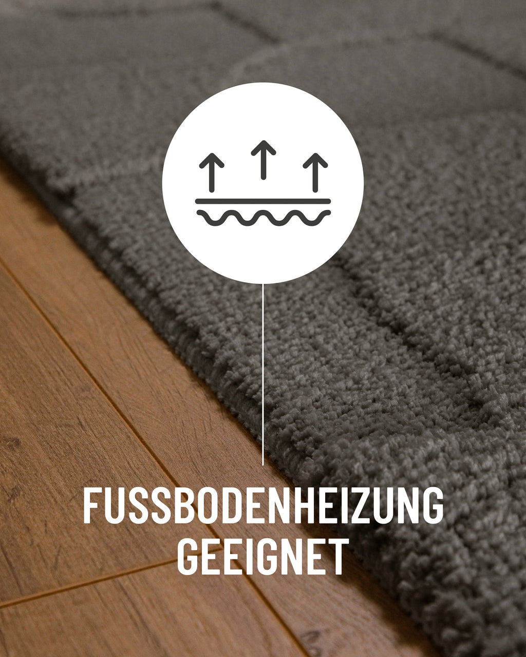 Badteppich von BathKing by WECONhome Davie Basalt Grau Detail auf Holzfußboden mit Symbol für Fußbodenheizung, Nahaufnahme von Flor und Teppichkante