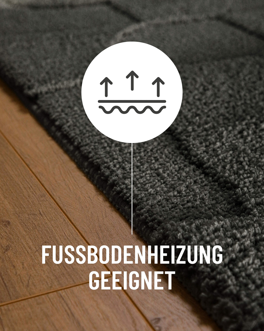 Badteppich von BathKing by WECONhome Davie Anthrazit Grau Detail auf Holzfußboden mit Symbol für Fußbodenheizung, Nahaufnahme von Flor und Teppichkante