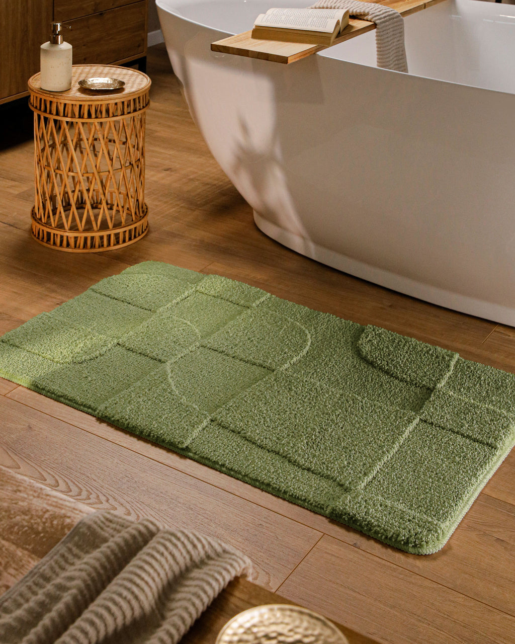 Badteppich von BathKing by WECONhome Davie Reseda Grün rechteckig im Badezimmer vor Badewanne auf Holzboden liegend, Strukturmuster im Flor sichtbar