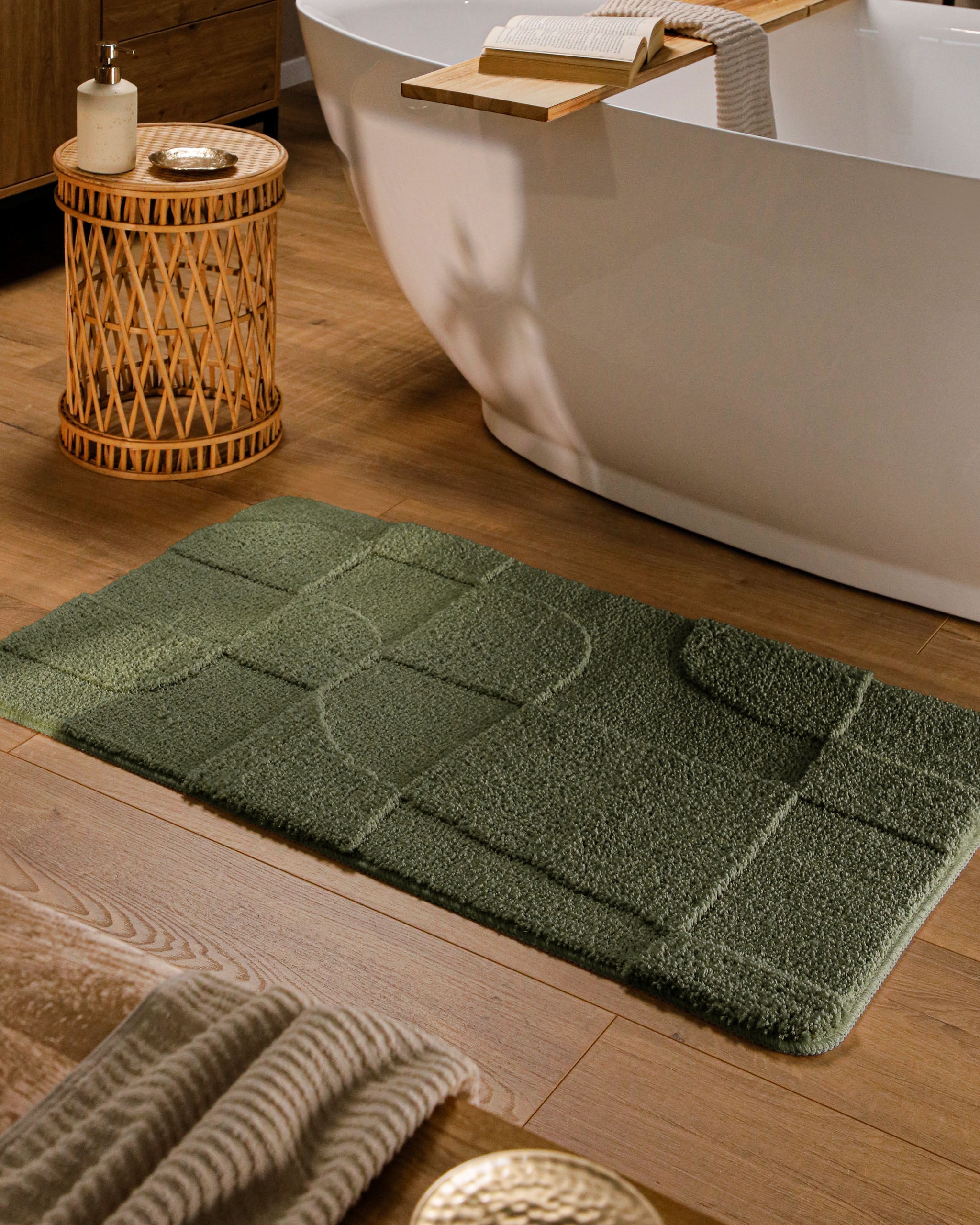 Badteppich von BathKing by WECONhome Davie Kiefer Grün rechteckig im Badezimmer vor Badewanne auf Holzboden liegend, Strukturmuster im Flor sichtbar