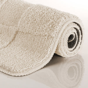 {"class" => "product-thumbnails__image", "alt" => "Badteppich von BathKing by WECONhome Davie Creme Weiß aufgerollt auf hellem Hintergrund, Seitenansicht zeigt Florhöhe und Teppichkante"}