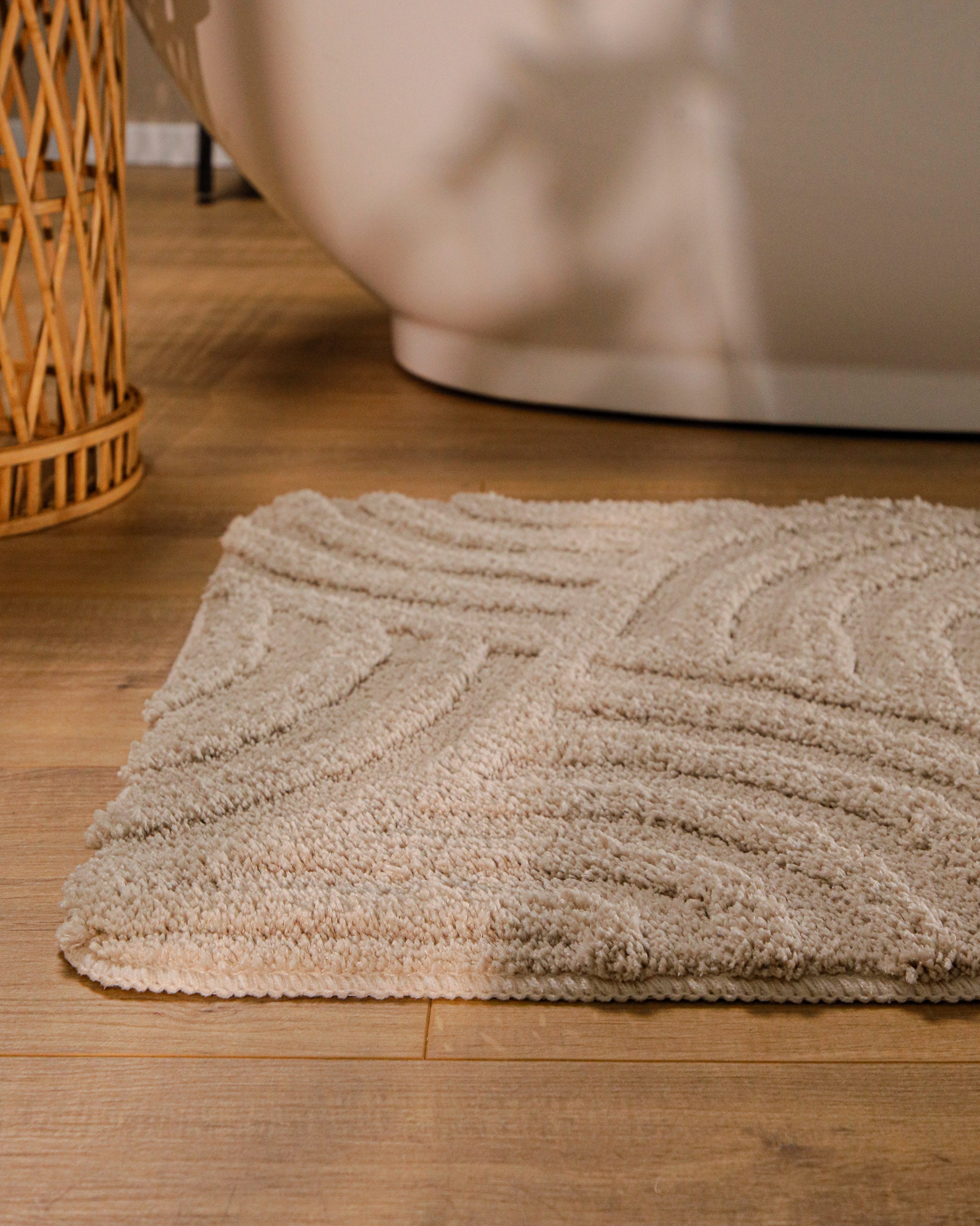 Badteppich von BathKing by WECONhome Fiete Sand Beige runde Matte im Badezimmer vor Badewanne, Strukturmuster im Flor auf Holzboden sichtbar