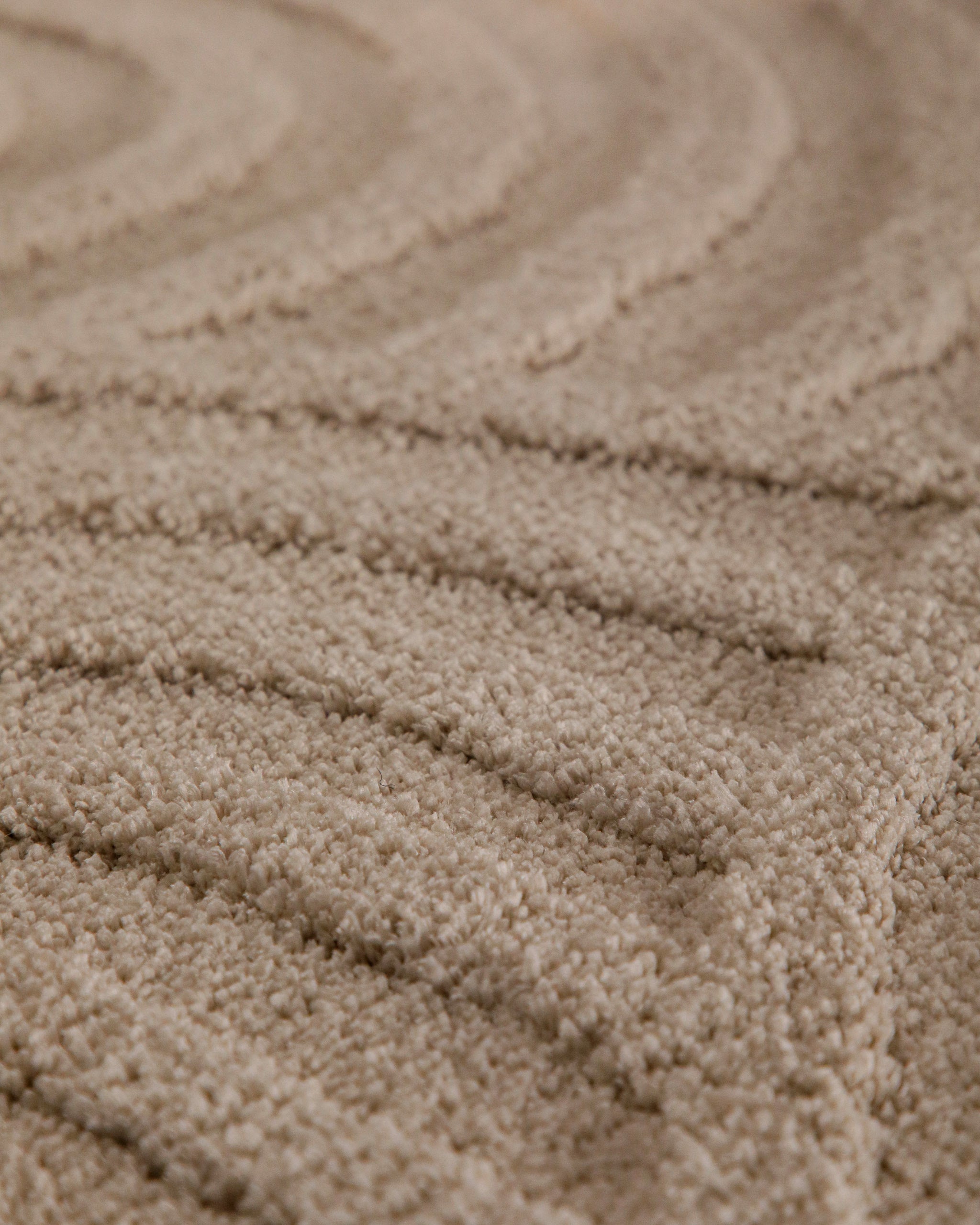 Badteppich von BathKing by WECONhome Fiete Sand Beige rund Detail der Teppichkante mit Hinweisen zu maschinengetufteter Verarbeitung