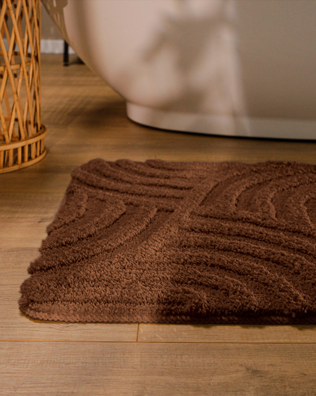 Badteppich von BathKing by WECONhome Fiete Braun runde Matte im Badezimmer vor Badewanne, Strukturmuster im Flor auf Holzboden sichtbar