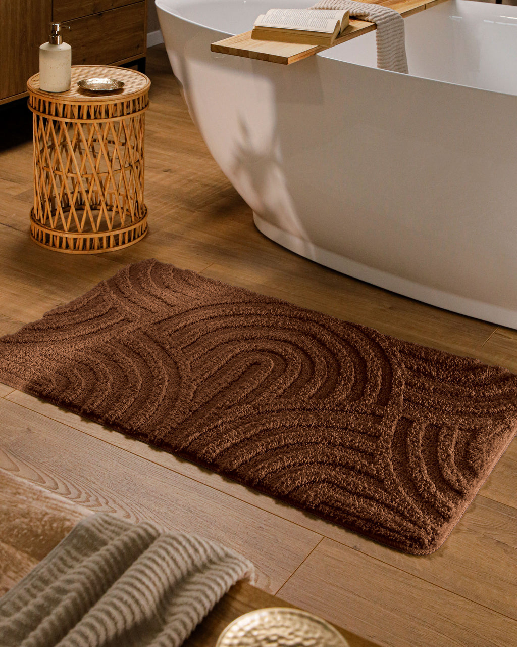 Badteppich von BathKing by WECONhome Fiete Braun rechteckig im Badezimmer vor Badewanne auf Holzboden liegend, Strukturmuster im Flor sichtbar