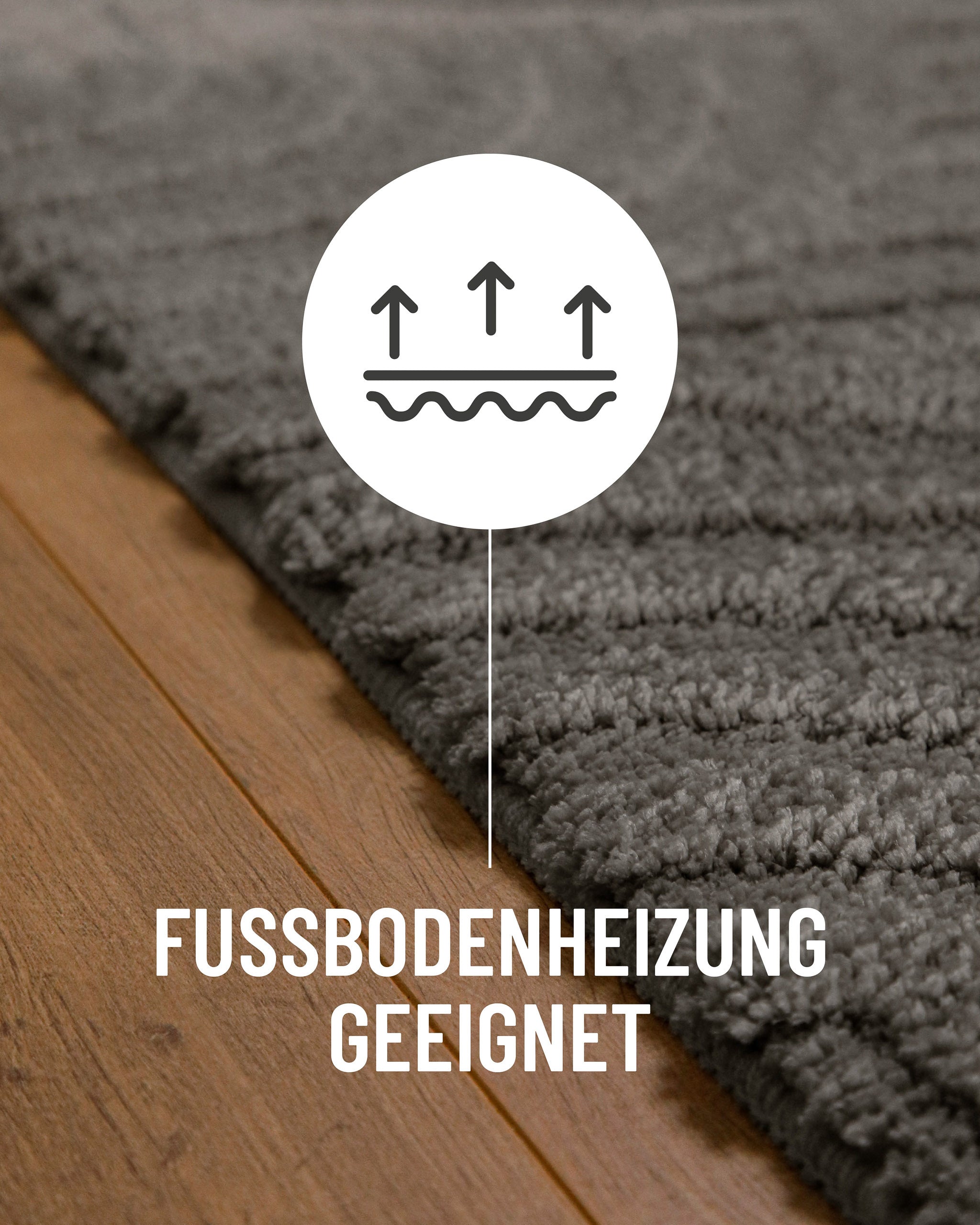 Badteppich von BathKing by WECONhome Fiete Basalt Grau Detail auf Holzfußboden mit Symbol für Fußbodenheizung, Nahaufnahme von Flor und Teppichkante