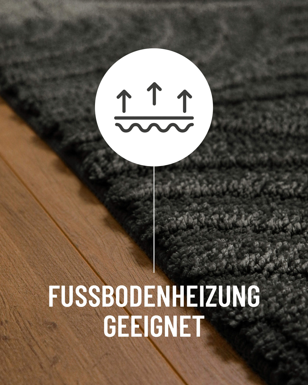 Badteppich von BathKing by WECONhome Fiete Anthrazit Grau Detail auf Holzfußboden mit Symbol für Fußbodenheizung, Nahaufnahme von Flor und Teppichkante