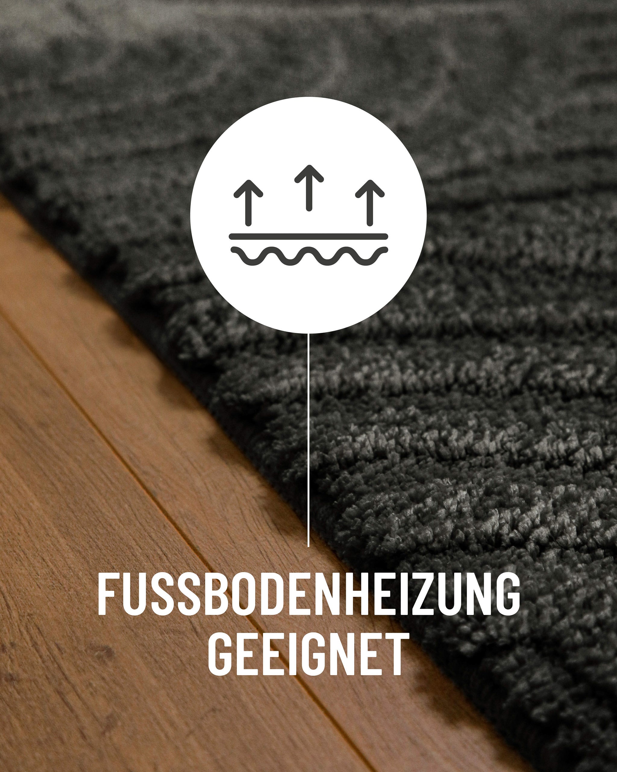 Badteppich von BathKing by WECONhome Fiete Anthrazit Grau Detail auf Holzfußboden mit Symbol für Fußbodenheizung, Nahaufnahme von Flor und Teppichkante