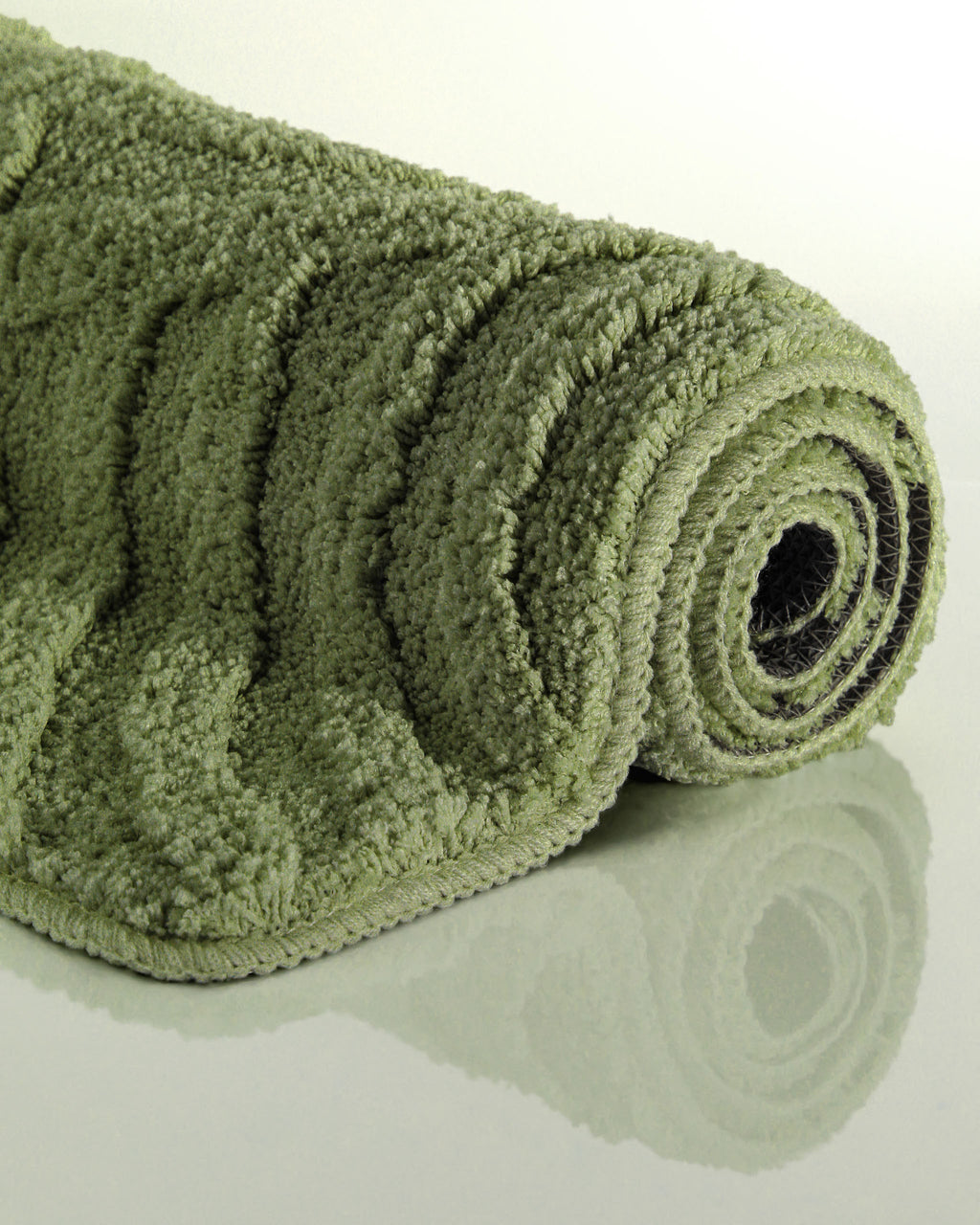 Badteppich von BathKing by WECONhome Fiete Reseda Grün aufgerollt auf hellem Hintergrund, Seitenansicht zeigt Florhöhe und Teppichkante