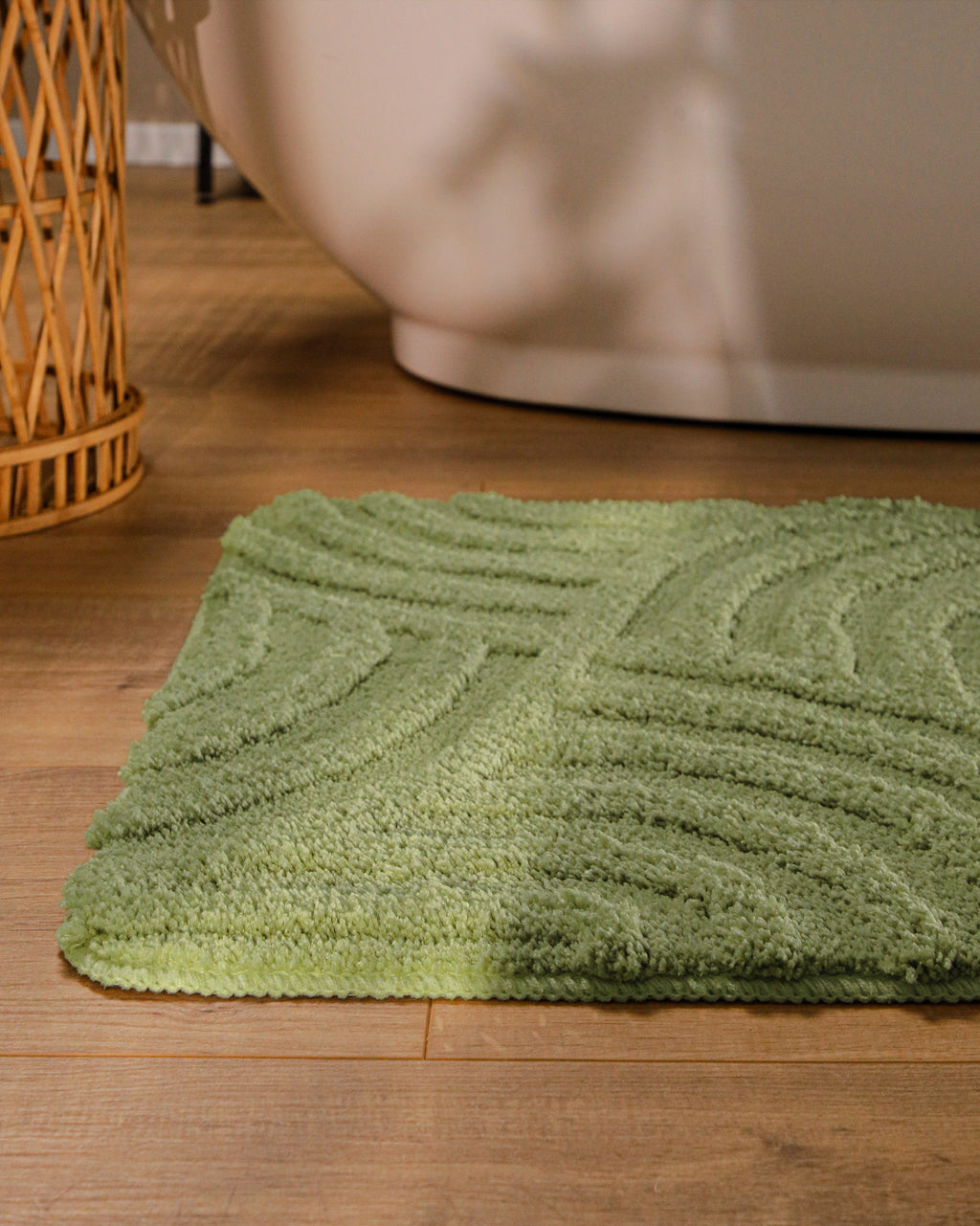 Badteppich von BathKing by WECONhome Fiete Reseda Grün runde Matte im Badezimmer vor Badewanne, Strukturmuster im Flor auf Holzboden sichtbar