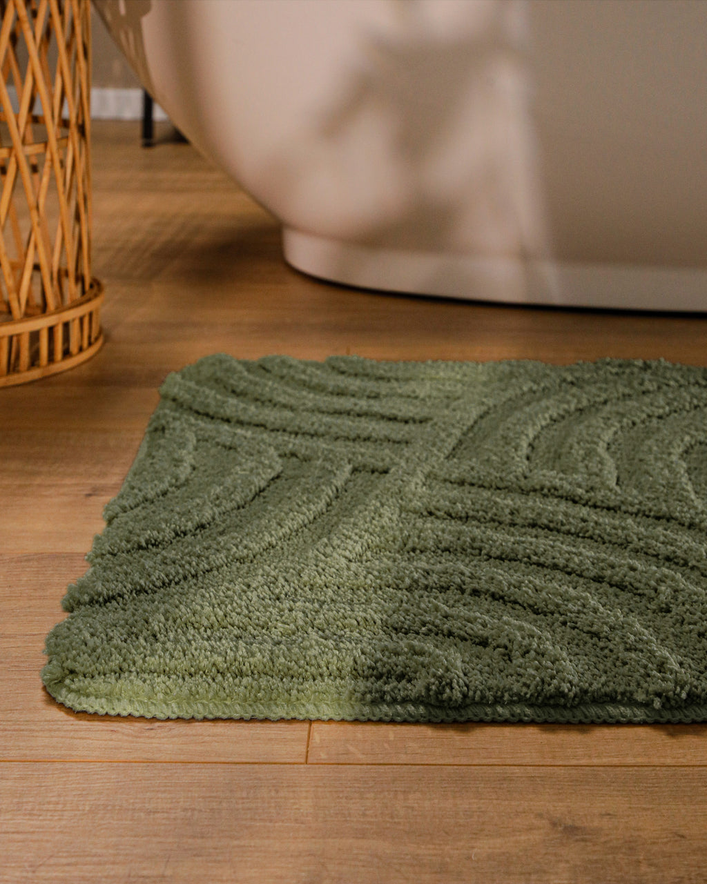 Badteppich von BathKing by WECONhome Fiete Kiefer Grün runde Matte im Badezimmer vor Badewanne, Strukturmuster im Flor auf Holzboden sichtbar