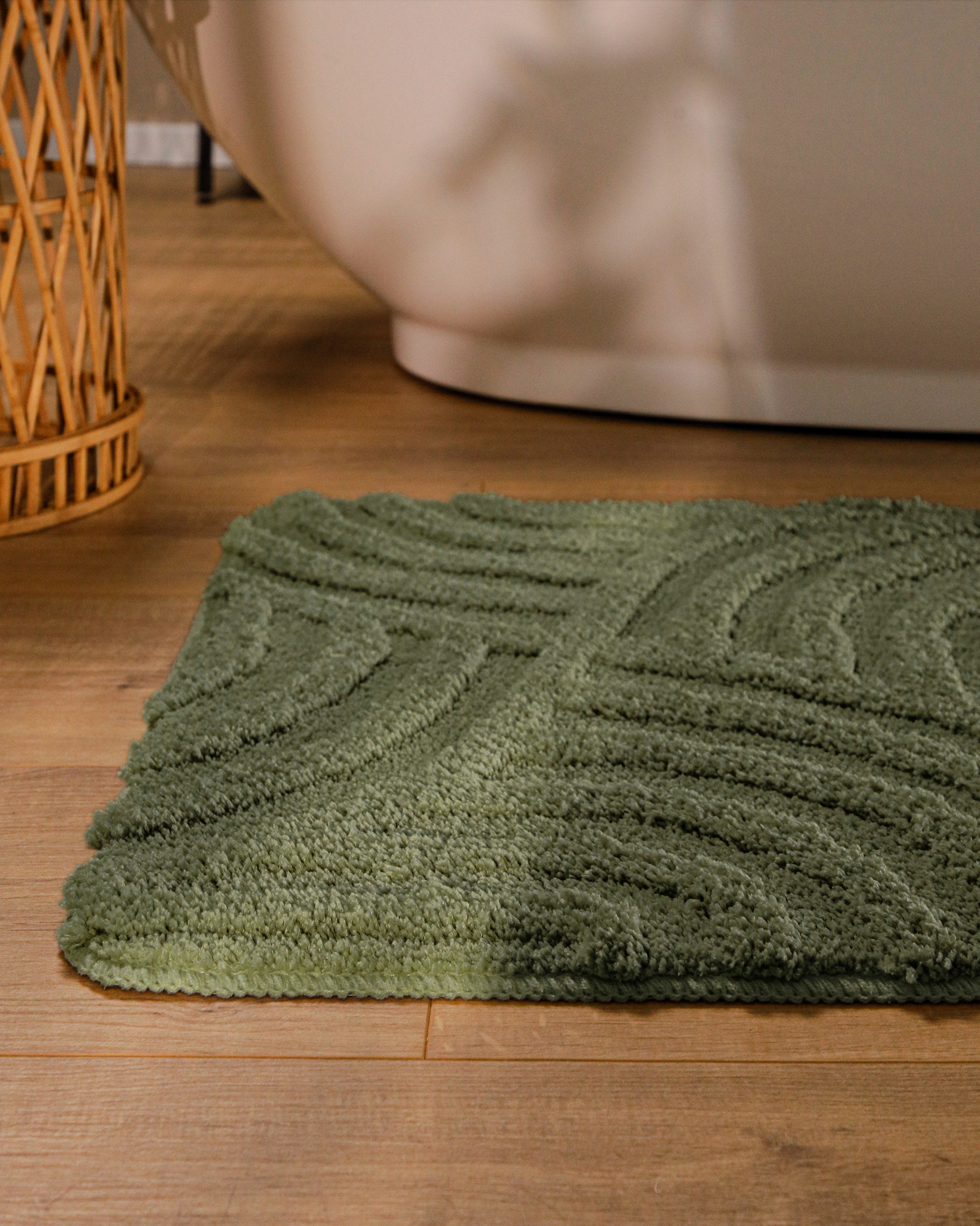 Badteppich von BathKing by WECONhome Fiete Kiefer Grün runde Matte im Badezimmer vor Badewanne, Strukturmuster im Flor auf Holzboden sichtbar