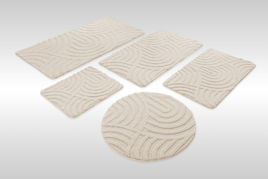 Badteppich von BathKing by WECONhome Fiete Creme Weiß Set aus rechteckigen und runden Badmatten, mehrere Größen auf hellem Hintergrund angeordnet