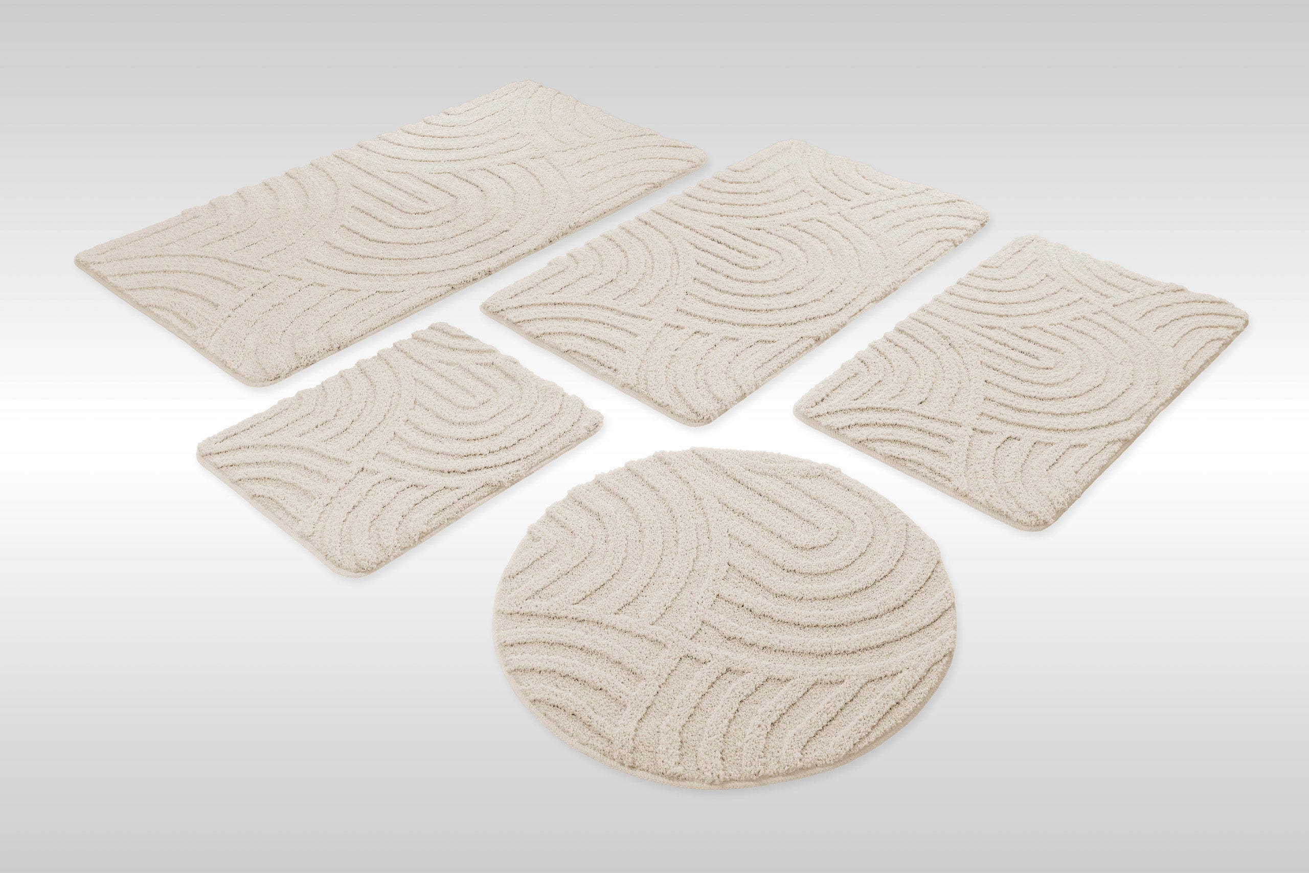 Badteppich von BathKing by WECONhome Fiete Creme Weiß Set aus rechteckigen und runden Badmatten, mehrere Größen auf hellem Hintergrund angeordnet