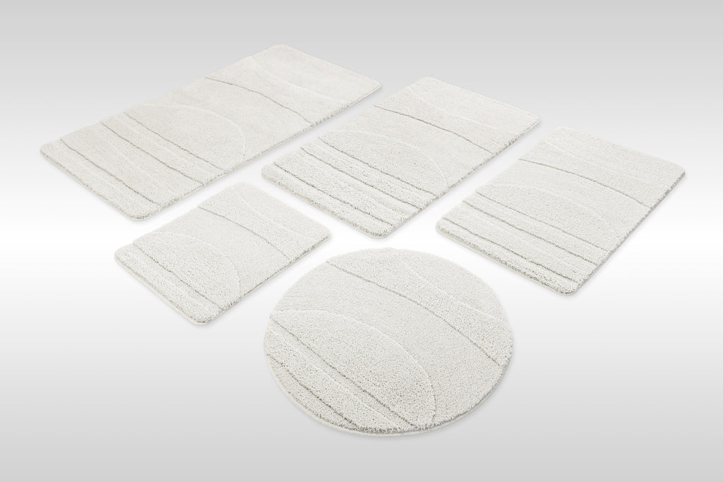 Badteppich von BathKing by WECONhome Marc Weiß Set aus rechteckigen und runden Badmatten, mehrere Größen auf hellem Hintergrund angeordnet