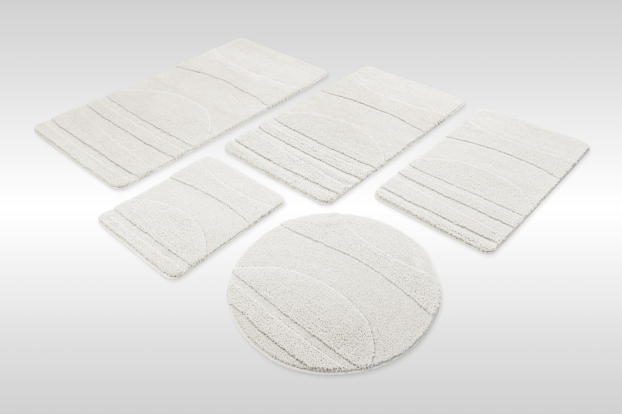 Badteppich von BathKing by WECONhome Marc Weiß Set aus rechteckigen und runden Badmatten, mehrere Größen auf hellem Hintergrund angeordnet