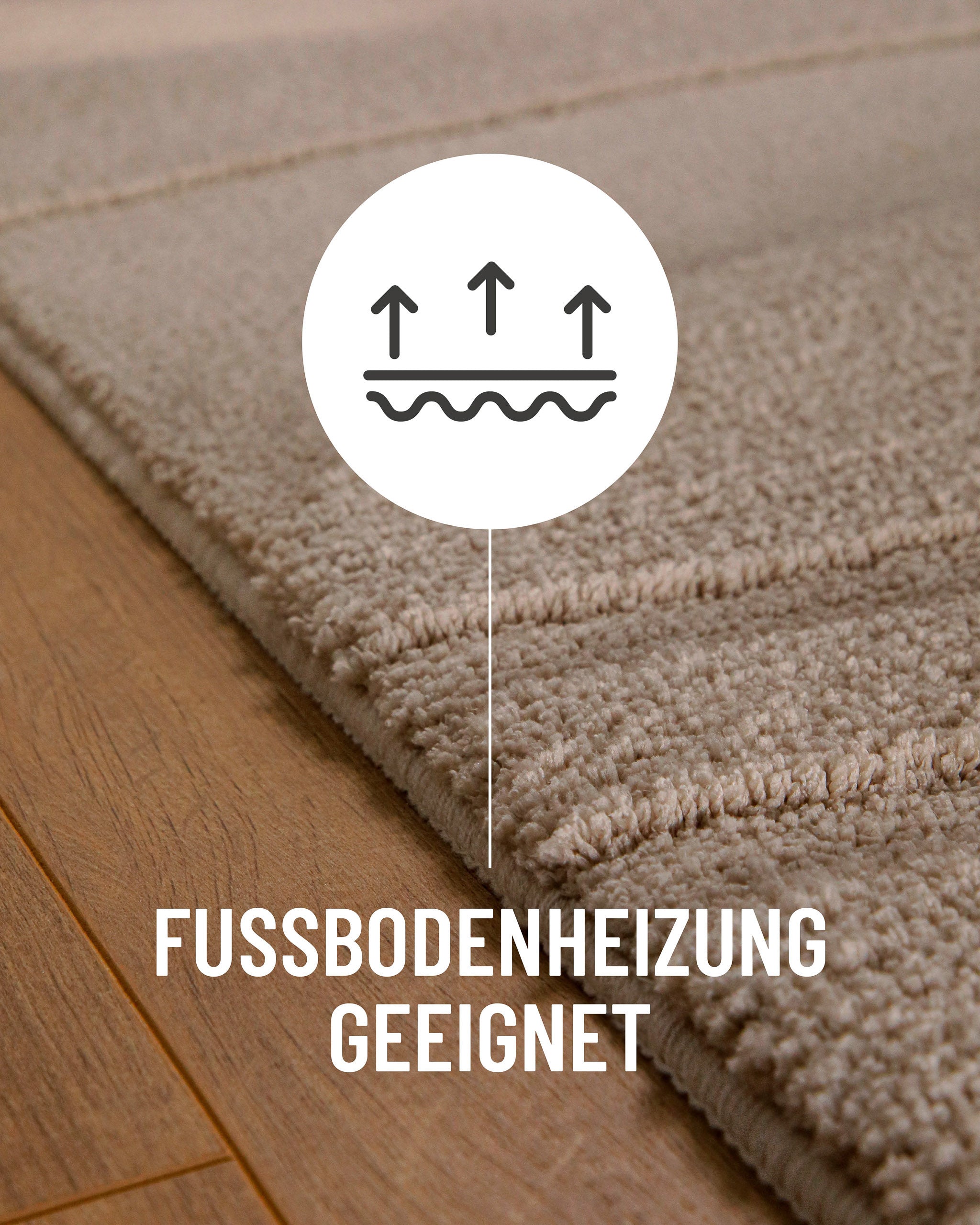 Badteppich von BathKing by WECONhome Marc Sand Beige Detail auf Holzfußboden mit Symbol für Fußbodenheizung, Nahaufnahme von Flor und Teppichkante