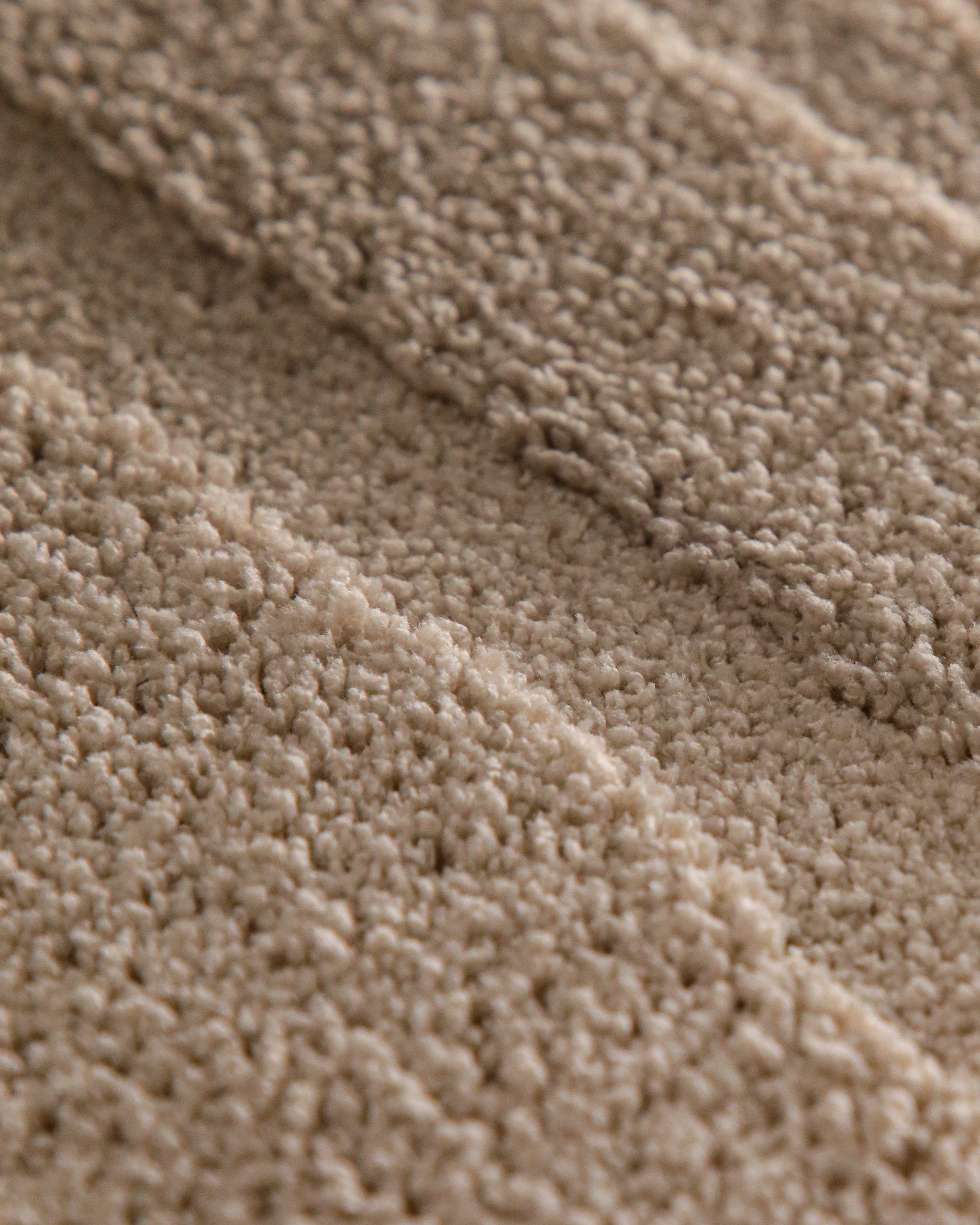 Badteppich von BathKing by WECONhome Marc Sand Beige rund Detail der Teppichkante mit Hinweisen zu maschinengetufteter Verarbeitung