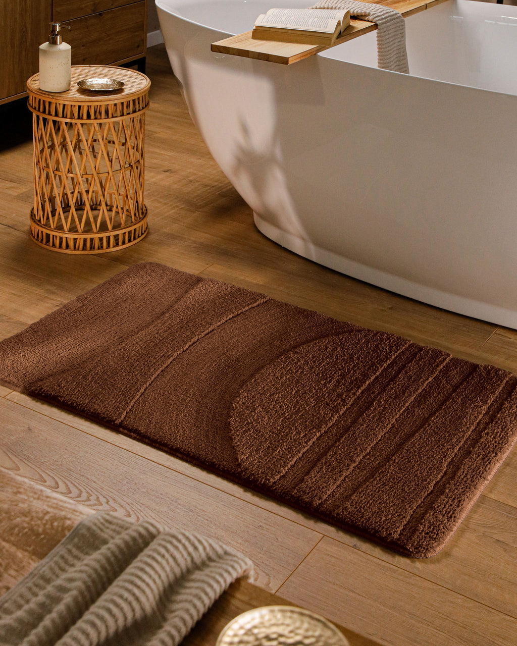 Badteppich von BathKing by WECONhome Marc Braun rechteckig im Badezimmer vor Badewanne auf Holzboden liegend, Strukturmuster im Flor sichtbar