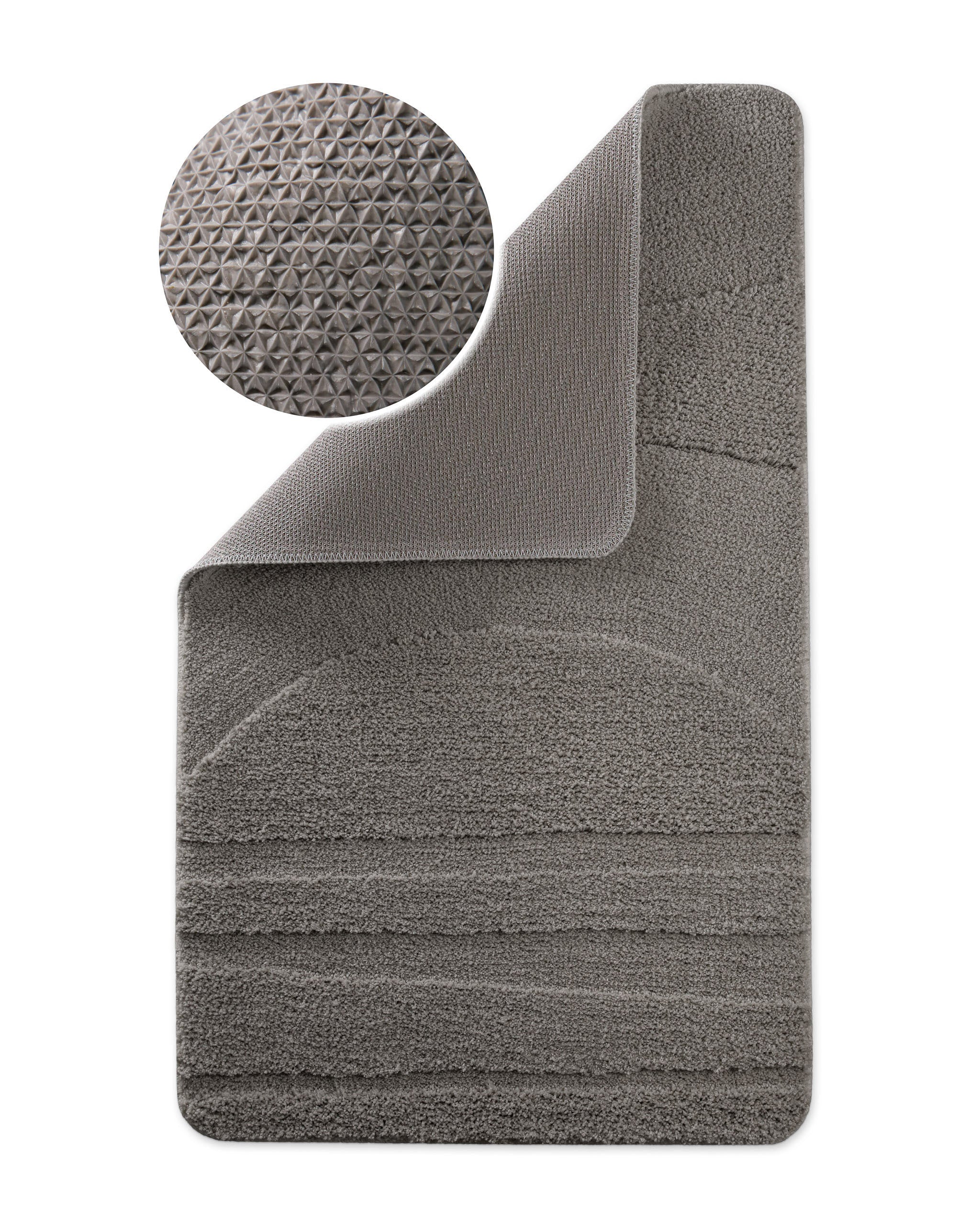 Badteppich von BathKing by WECONhome Marc Basalt Grau Ecke hochgeklappt, runde Probe zeigt Basalt Graue Rückseite mit rutschhemmender Beschichtung
