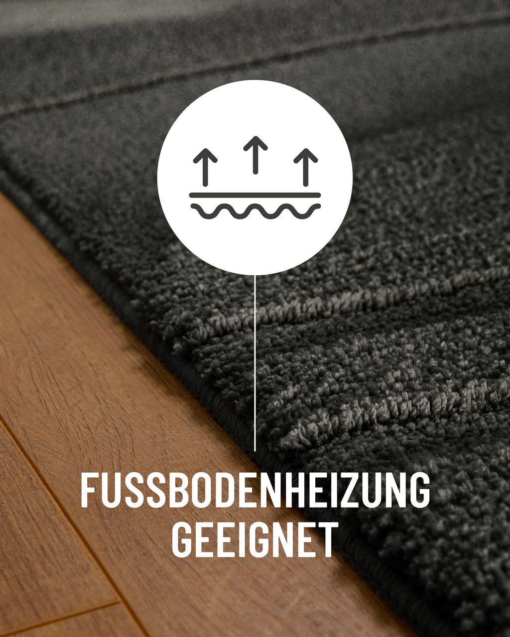 Badteppich von BathKing by WECONhome Marc Anthrazit Grau Detail auf Holzfußboden mit Symbol für Fußbodenheizung, Nahaufnahme von Flor und Teppichkante