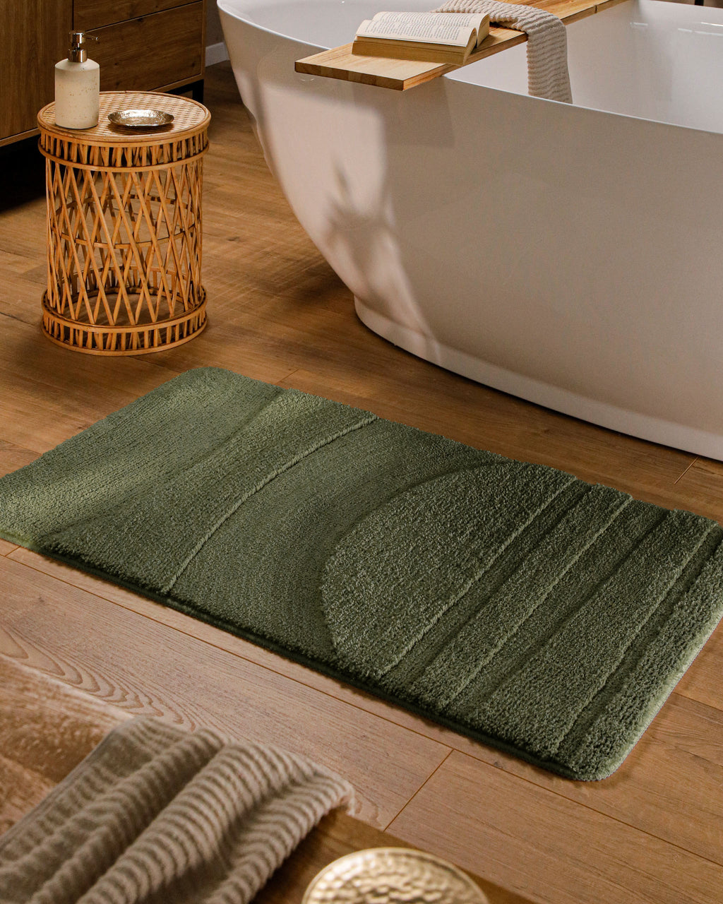 Badteppich von BathKing by WECONhome Marc Kiefer Grün rechteckig im Badezimmer vor Badewanne auf Holzboden liegend, Strukturmuster im Flor sichtbar