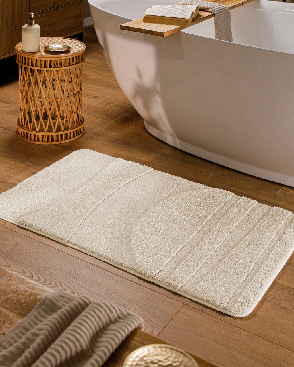 Badteppich von BathKing by WECONhome Marc Creme Weiß rechteckig im Badezimmer vor Badewanne auf Holzboden liegend, Strukturmuster im Flor sichtbar