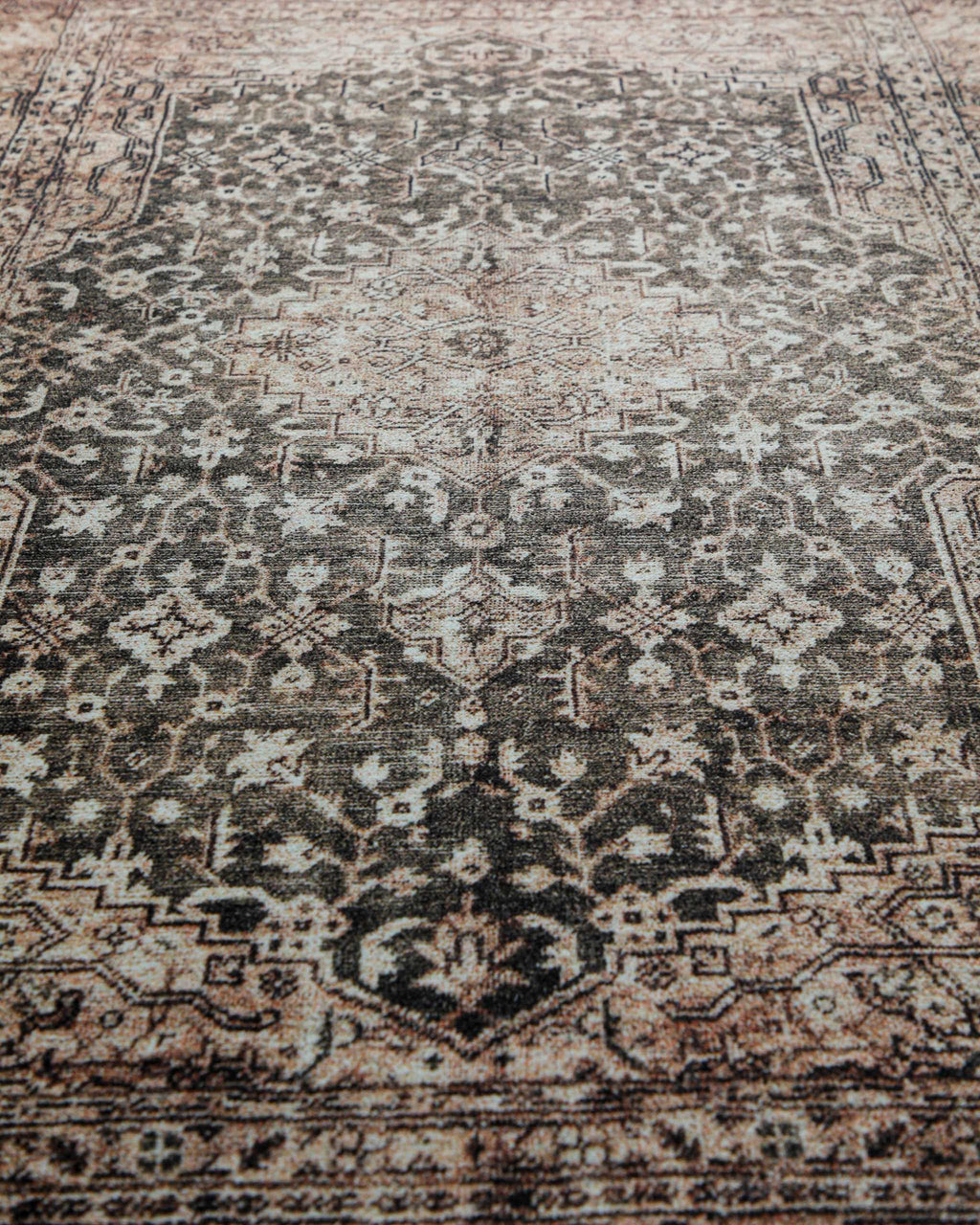 Makroaufnahme der weichen Oberfläche und des detailreichen Ethno-Musters des beige-grauen Badteppichs Ralph.