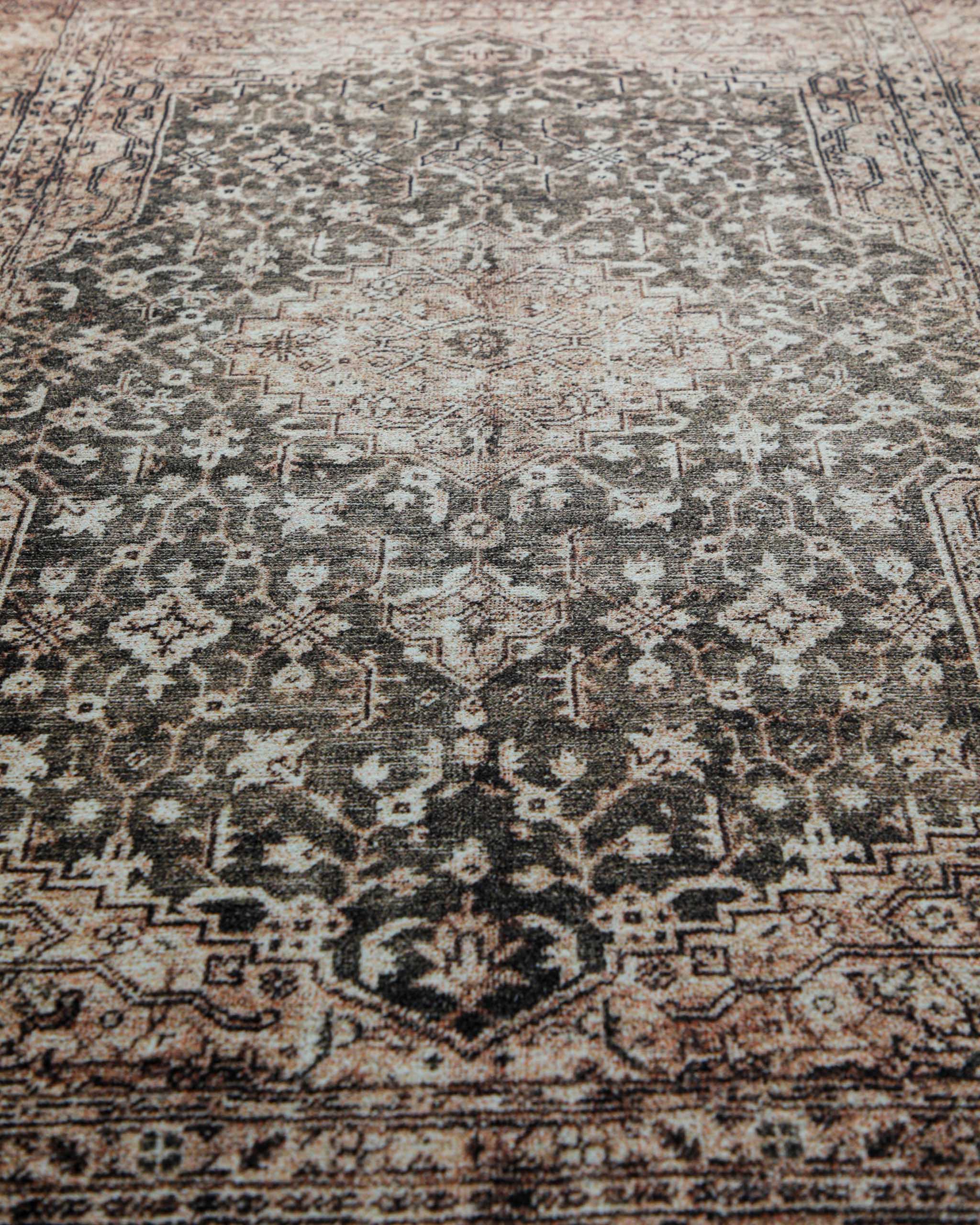 Makroaufnahme der weichen Oberfläche und des detailreichen Ethno-Musters des beige-grauen Badteppichs Ralph.