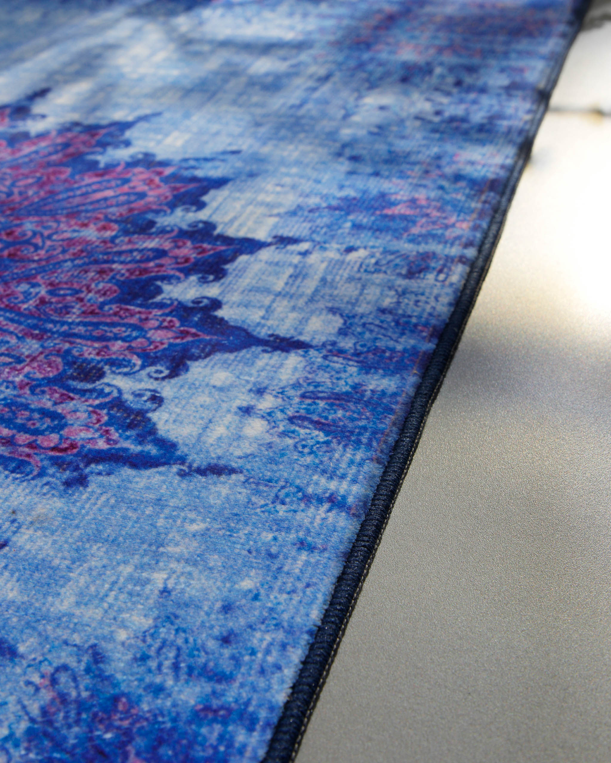 Nahaufnahme der eingefassten Kante des Vintage-Badteppichs Healing in Blau-Multi.