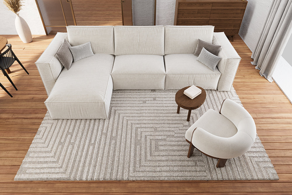 Helles Wohnzimmer mit Eckcouch und Sessel und einem Teppich darunter
