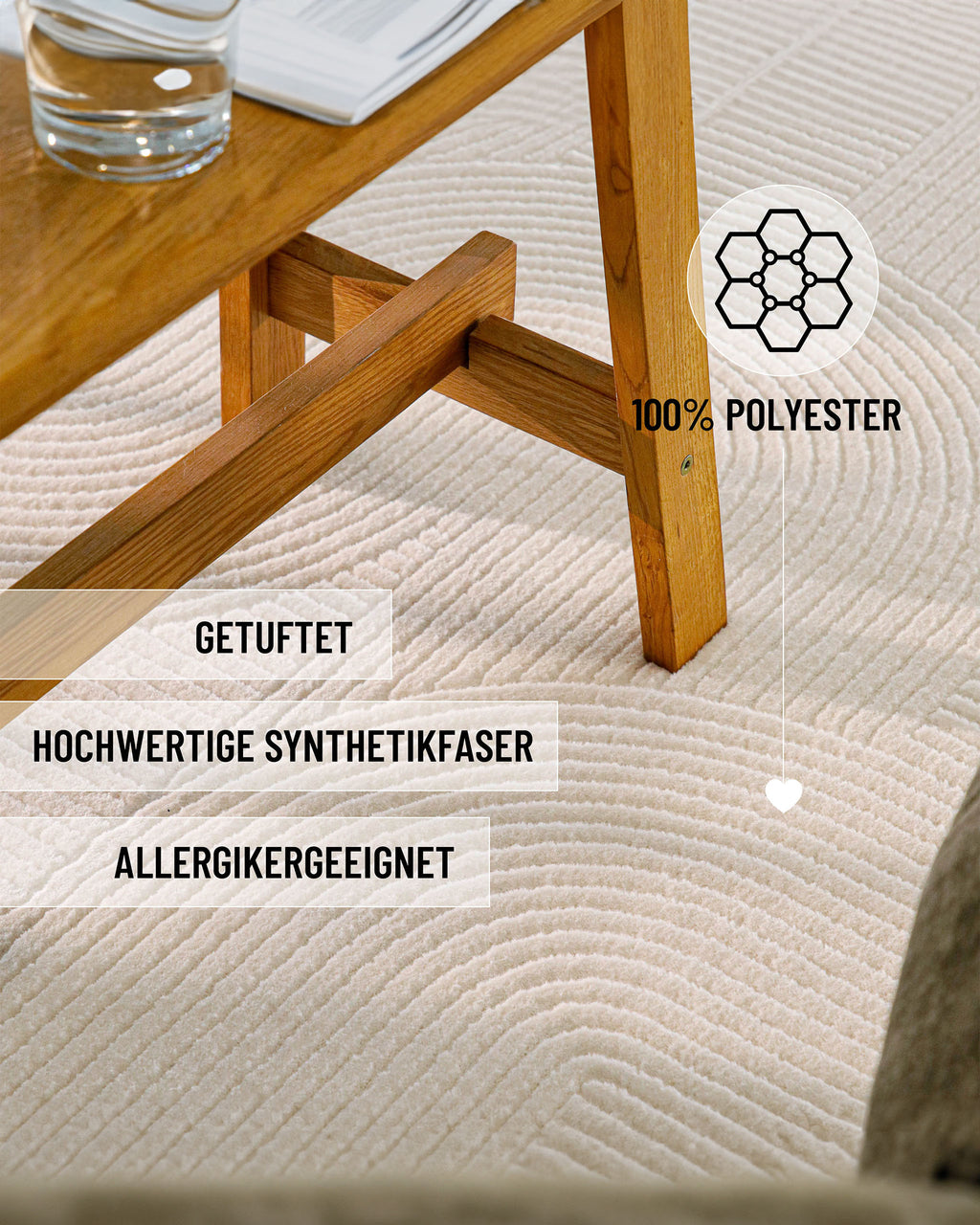 Detailansicht WECONhome Kurzflorteppich Nuuk Arc in Creme Weiß unter einem Holztisch mit Infos: 100% Polyester, getuftet und für Allergiker geeignet