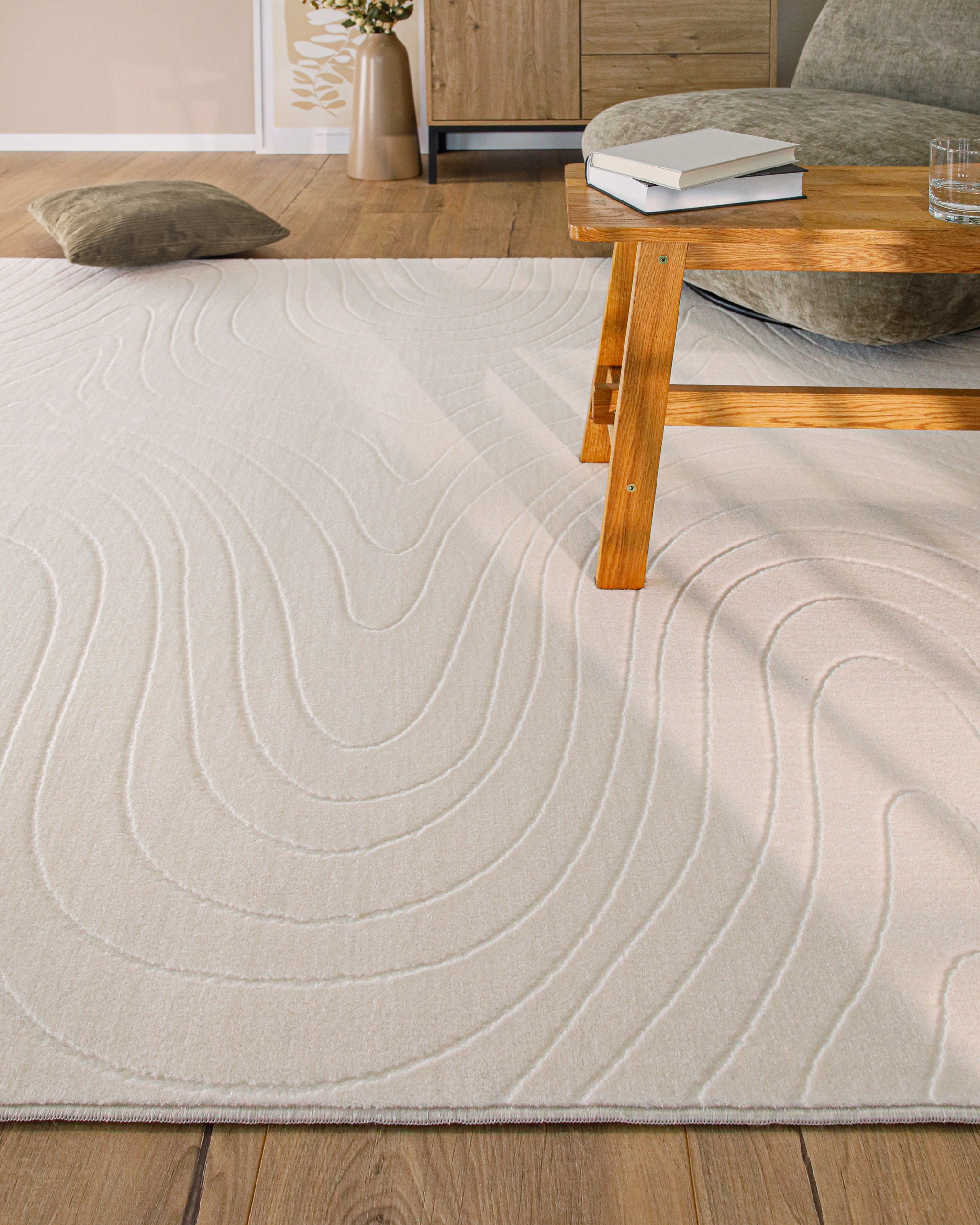 Kurzflor Teppich creme Nuuk Flow stilvoll im Wohnzimmer unter einem Sessel