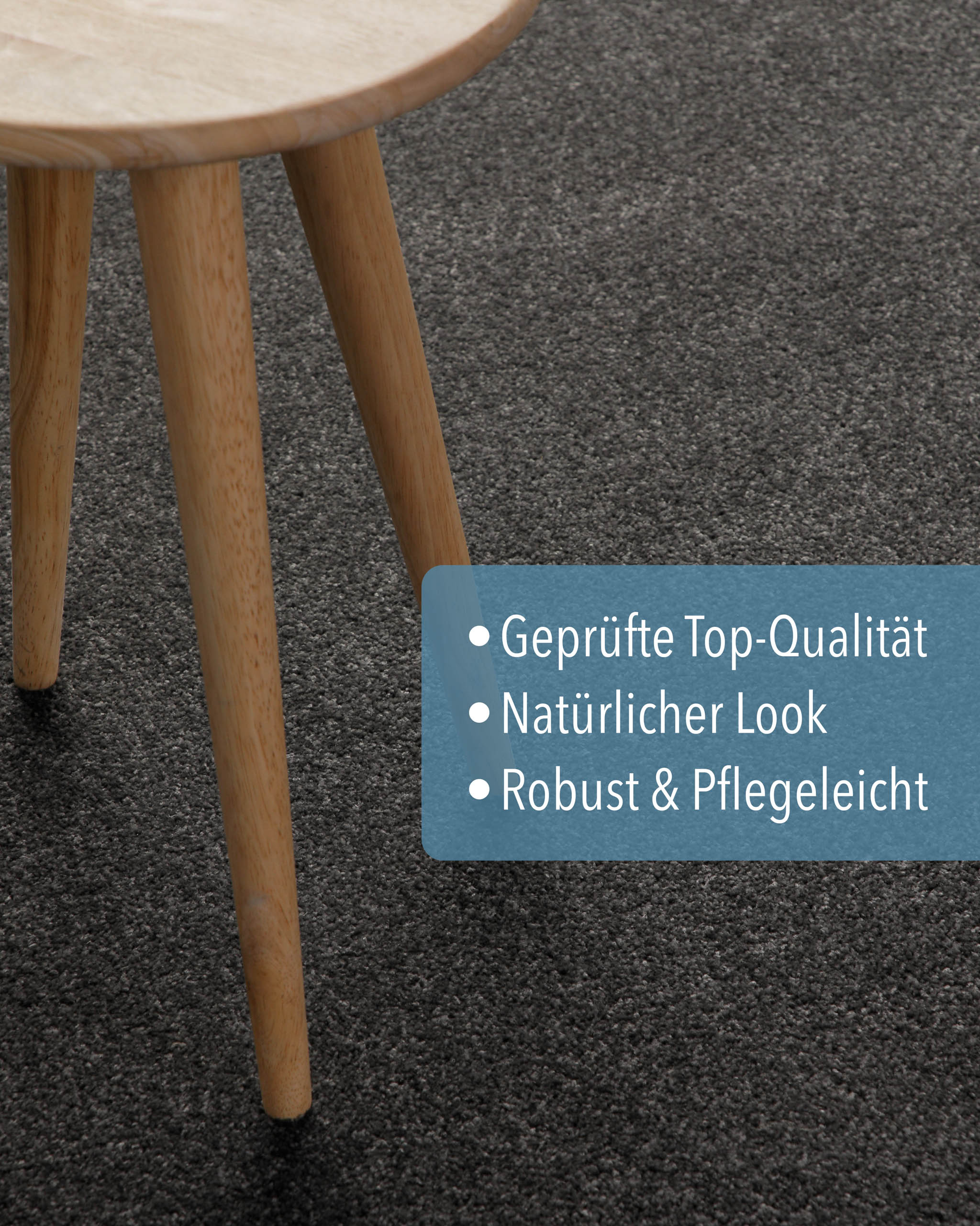 Kurzflor Teppich Montepulciano Anthrazit Grau rund im Wohnraum, zeigt natürliche Wirkung unter einem Holz-Hocker