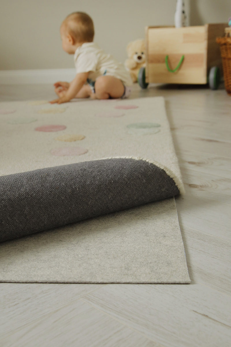 RugPad liegt unter einem Teppich mit hochgeklappter Ecke im Kinderzimmer